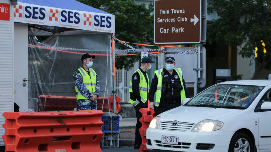Police and defence personnel check on cars crossing the Qld-NSW border at Coolangatta.
