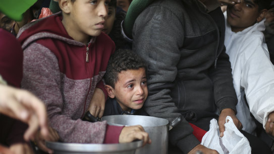 Palestinians line up for free food distribution during the ongoing Israeli air and ground offensive in Khan Younis, Gaza Strip, last month.