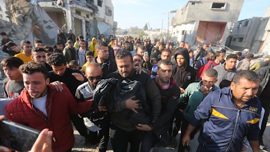 A Palestinian carries a relative killed in the Israeli bombardment of the Gaza Strip in Rafah.