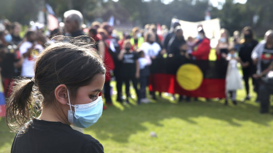 A woman reflects at a Black Lives Matter rally in The Domain on Sunday.
