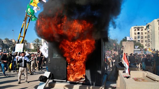 Protesters burn property in front of the US embassy compound, in Baghdad.
