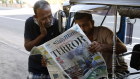 People read a newspaper the day after multiple blasts killed hundreds in Colombo, Sri Lanka,.