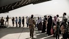 Afghan evacuees wait to board an air force place to leave Kabul in 2021.