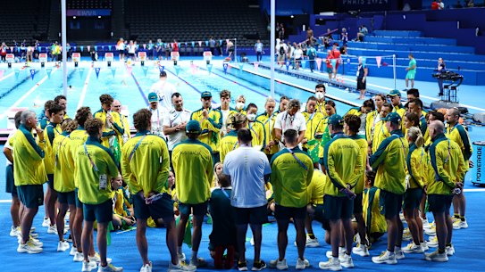 The Australian swim team huddle on pool deck in Paris.