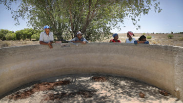 Farmers gather at a broken windmill and empty dam where they have to pump underground water into buckets in Vosburg, South Africa. 