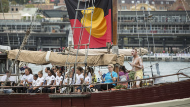 A boat with the Aboriginal flag holds a smoking ceremony in Sydney Cove on Australia Day in 2017.
