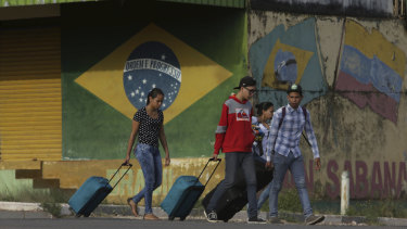 Young Venezuelans pull their luggage after crossing the border to Pacaraima, Roraima state, Brazil.