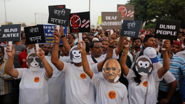 An Indian man wearing a mask of Mahatma Gandhi participates with others in a rally to protest against recent incidents of rape, in Ahmadabad, India, on Wednesday. 