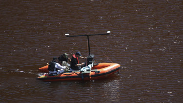 Police use sonar monitoring equipment on a toxic lake in Mitsero, near Cyprus' capital Nicosia, on Saturday. The sonar scans form part of the search for suitcases in which a self-confessed serial killer placed bodies.