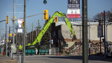 A crew works to demolish a building next to the site of last summer’s gas explosion in Wheatley, Ontario.