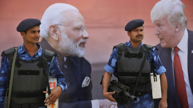 Indian paramilitary personnel stand guard next to a billboard featuring US President Donald Trump and Indian Prime Minister Narendra Modi in Agra, home of the Taj Mahal.