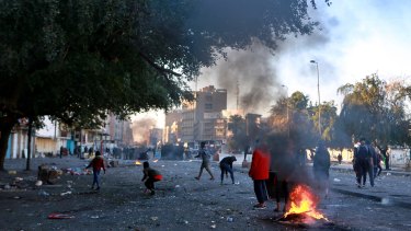Protesters set fire to close a street during clashes between security forces and anti-government protesters near Baghdad's Khilani square, Iraq, on Sunday.