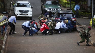People take cover after an attack on a hotel in Nairobi on Tuesday.