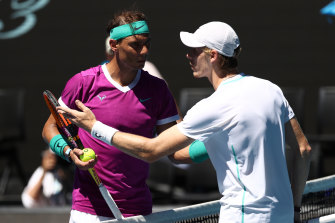 Rafael Nadal and Denis Shapovalov talk at the net.