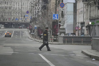 A man wearing the yellow armband of the civil defense crosses a deserted boulevard during an air raid alarm in Kyiv on March 1. 