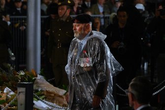 A returned serviceman at the Cenotaph in the rain for the Anzac Day dawn service.