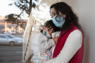 Leidy Castro Meneses with her daughter, Sofia, in the lobby of their Yagoona apartment building. She is relieved to be vaccinated now that the virus is raging in her local area.