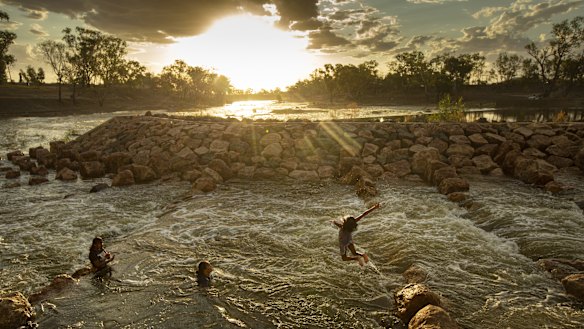 Kids swimming in the fishway at Brewarrina Weir, north-west NSW in February when the first strong flows in years came down the dry Barwon River in the Murray Darling Basin. 