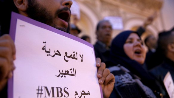 An activist holds up a placard that reads "No to repression of freedom of expression #MBS criminal" on the eve of Saudi Crown Prince Mohammed bin Salman's official visit to Tunisia.