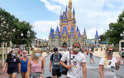 Guests wear masks as required at the Magic Kingdom at Walt Disney World in Florida. 