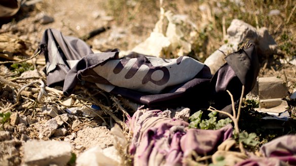 An Islamic State militant flag lies in a tent encampment after US-backed SDF fighters took control of Baghouz, Syria on Saturday.