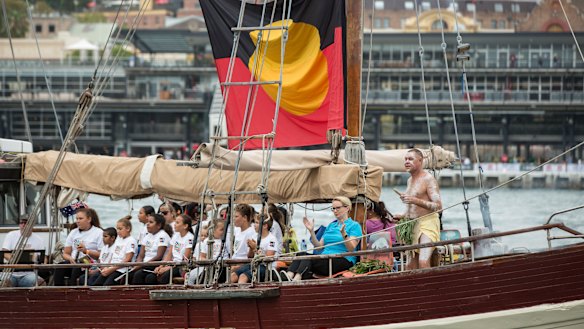 A boat with the Aboriginal flag holds a smoking ceremony in Sydney Cove on Australia Day in 2017.
