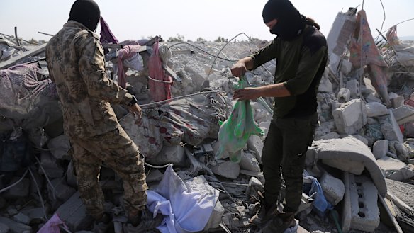 People look at a destroyed houses near the village of Barisha, in Idlib province, Syria after an operation by the US military that targeted Abu Bakr al-Baghdadi. 
