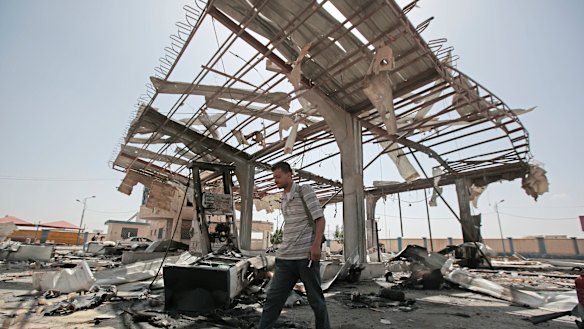 A Yemeni man walks on the rubble of a petrol station after it was hit by Saudi-led airstrikes in Sanaa, Yemen, late last month.