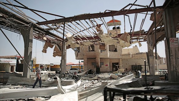 A Yemeni man walks among the rubble of a petrol station after it was hit by Saudi-led airstrikes in Sanaa in late May.