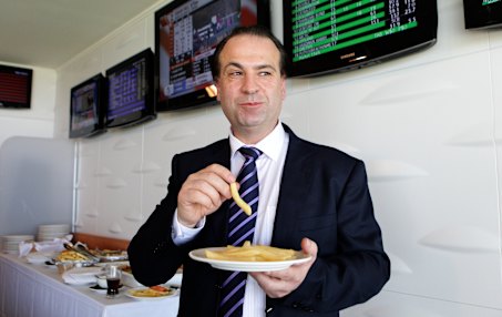 Peter V’landys photographed enjoying a plate of hot chips in 2012.