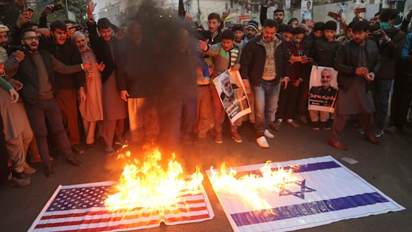 Shiite Muslims burn representations of US and Israeli flags near the US consulate in Lahore, Pakistan in protest over the air strike that killed the Iranian general.