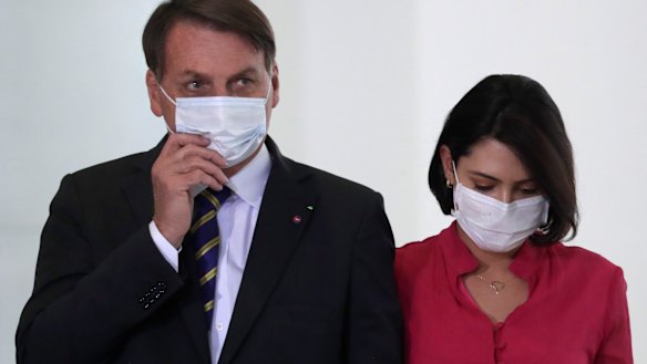Brazil's President Jair Bolsonaro and his wife Michelle at an event in Brasilia on Wednesday, a day before she tested positive for COVID-19.