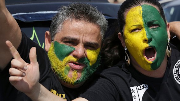 With their faces painted with the colours of Brazil, demonstrators shout slogans during a race in support of Jair Bolsonaro.