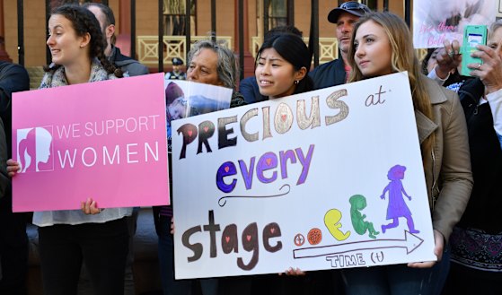 Anti-abortion protesters hold signs during a rally outside NSW Parliament.