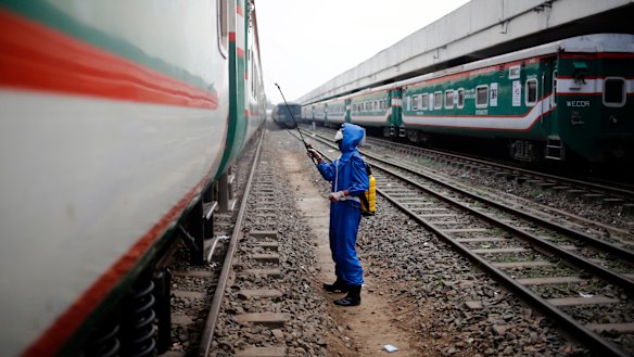 A volunteer sprays disinfectant on a train, in an effort to prevent coronavirus, at the Kamlapur Railway Station in Dhaka, Bangladesh in March.