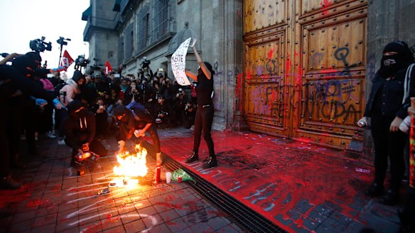 Protesters covered the entrance to the  National Palace in Mexico City in fake blood and the message: "Femicide State".