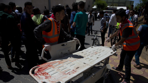 Palestinian medics stand by a bloodied stretcher outside a morgue in Beit Lahiya, Gaza Strip on Monday.