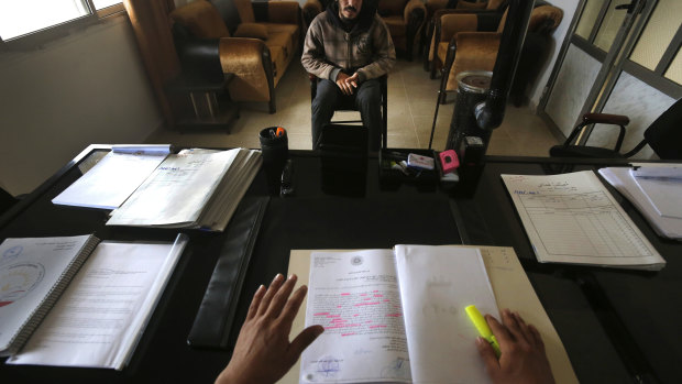 A 19-year-old Syrian former IS member sits opposite a panel of judges in the courtroom of a Kurdish-run terrorism court, in Qamishli, north Syria. 