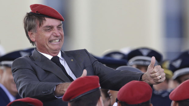  Jair Bolsonaro flashes two thumbs up as he poses for a photo with cadets during a ceremony marking Army Day, in Brasilia, Brazil.  