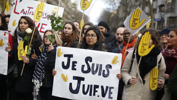 A woman carries a poster reading "I am a jew" as she attends a silent march to honour an 85-year-old woman who escaped the Nazis 76 years ago but was stabbed to death last week in her Paris apartment, apparently because she was Jewish.