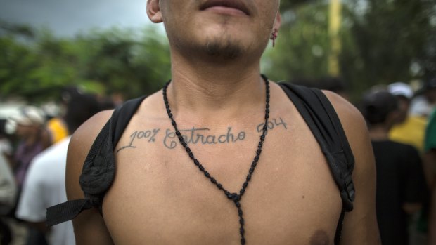 Honduran migrant Jose Santos Izaguirre shows his tattoo that reads in Spanish: "Hundred percent Catracho 504," with Catracho referring to his nationality and the number 504 is Honduras' country code.