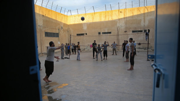 Prisoners play volleyball, in a Kurdish-run prison in Qamishli housing former members of IS.