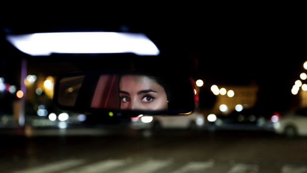Hessah al-Ajaji drives her car down the capital's busy Tahlia Street after midnight for the first time in Riyadh, Saudi Arabia on June 24.