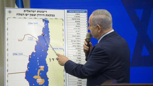 Benjamin Netanyahu points to a redrawn map in September as he pledged to annex the Jordan Valley in occupied West Bank if re-elected. The move would leave West Bank Palestinians with only a landlocked island, in orange, within Israel.