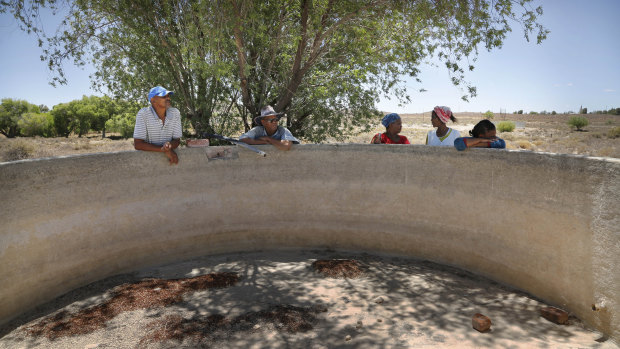 Farmers gather at a broken windmill and empty dam where they have to pump underground water into buckets in Vosburg, South Africa. 