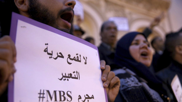 An activist holds up a placard that reads "No to repression of freedom of expression #MBS criminal" on the eve of Saudi Crown Prince Mohammed bin Salman's official visit to Tunisia.