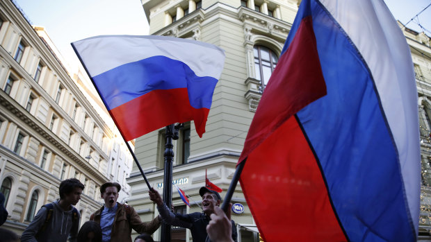 Some Russian fans wave the national flag in Moscow on the eve of the World Cup.