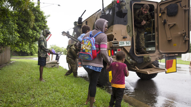 Army personal assist a family evacuating rising flood waters in Rosslea, Townsville.