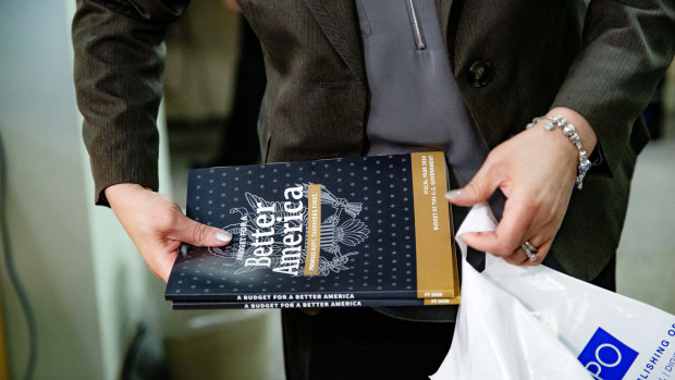 An employee bags purchased copies of US President Donald Trump's 2020 budget request in Washington.