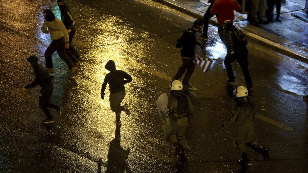 Greek riot police chase the demonstrators in Athens.